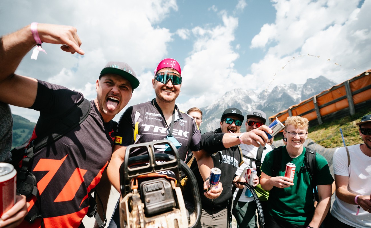 Gruppe fröhlicher Menschen mit Getränken posiert im Freien vor einer Bergkulisse © saalfelden-leogang.com Fotograf: MAblinger