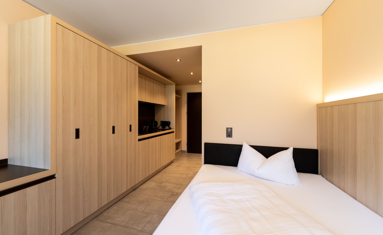 moderbes und helles Zimmer mit Holzeinrichtung im Hotel Stoanest in Leogang